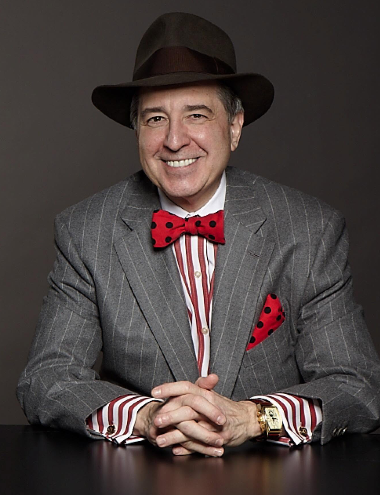 Dr. John Tantillo, The Marketing Doctor, seated in gray pinstripe suit with red bow tie
